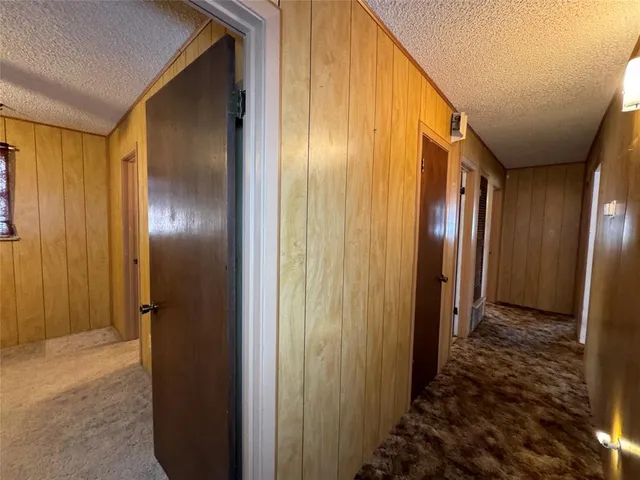a view of a hallway with wooden walls