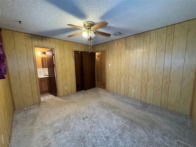 an empty room with closet and a chandelier fan