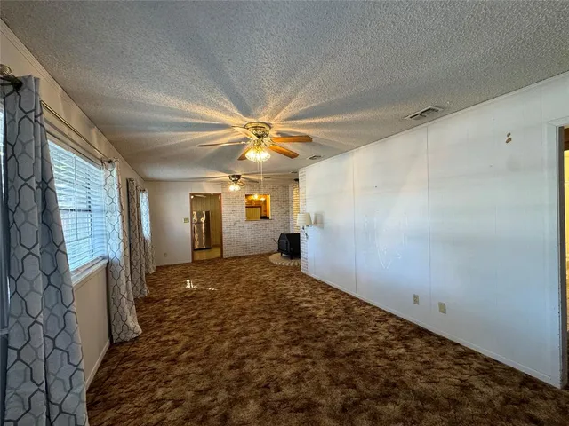 a view of a livingroom with a chandelier fan and a window