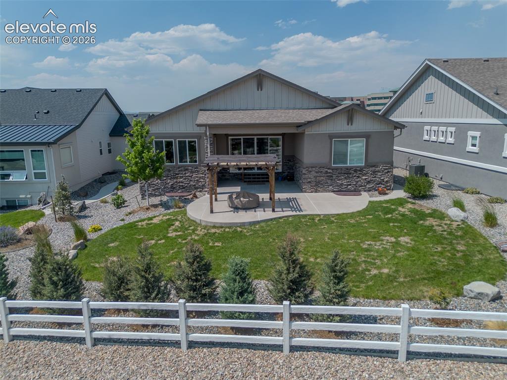 1061 Native Dancer Terrace Colorado Springs, CO 80921 - Photo 49 of 50 Expansive backyard featuring a manicured lawn, a concrete patio, and a wooden pergola structure