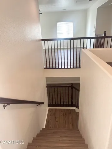 a view of a hallway with wooden floor and a window