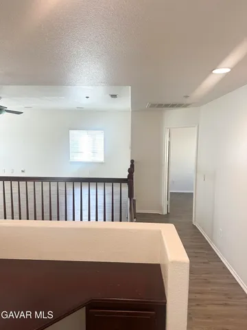 a hallway with wooden floor windows and stairs