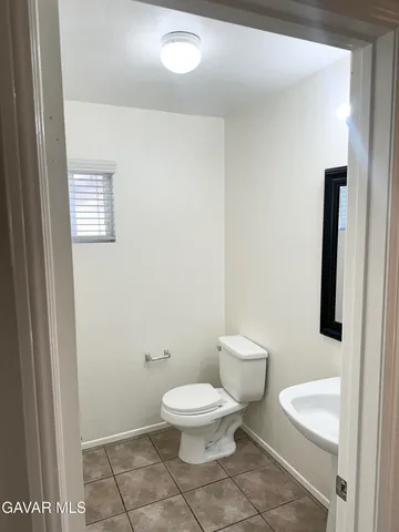 a view of an empty room with wooden floor and a fireplace