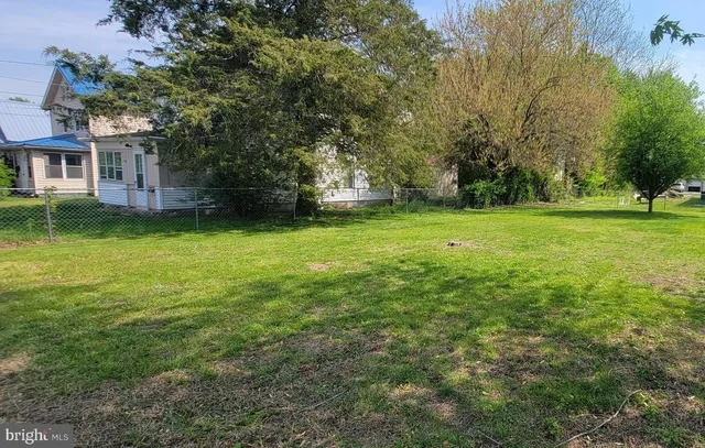 a view of a big yard with a house in the background