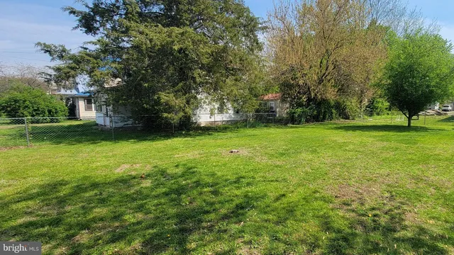a view of a big yard with a house and large trees