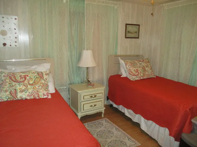 a bedroom with a bed and a lamp on dresser