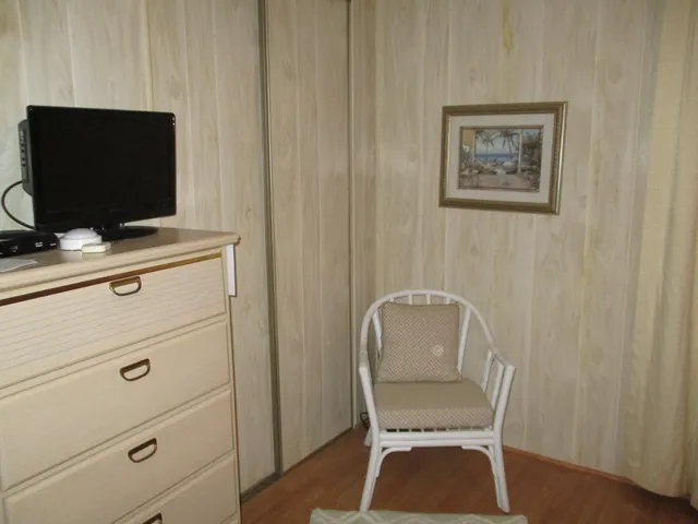 a bedroom with a chair and a flat screen tv