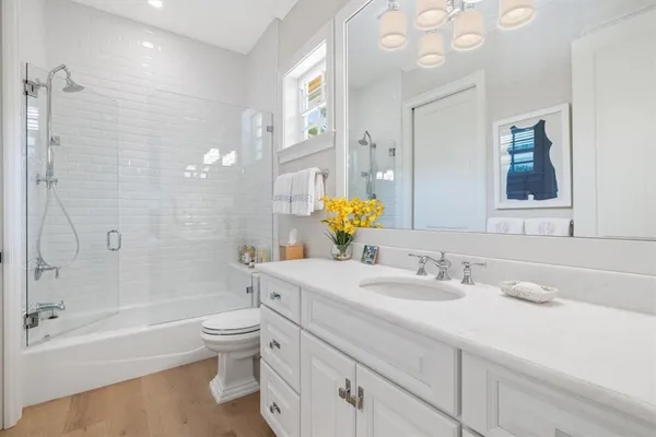 a bathroom with a sink a toilet and shower