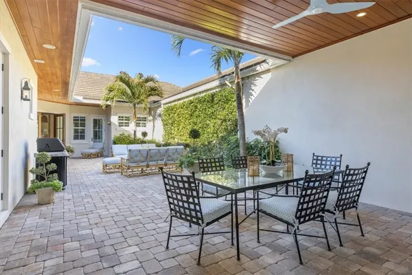 a view of a patio with a table and chairs and potted plants