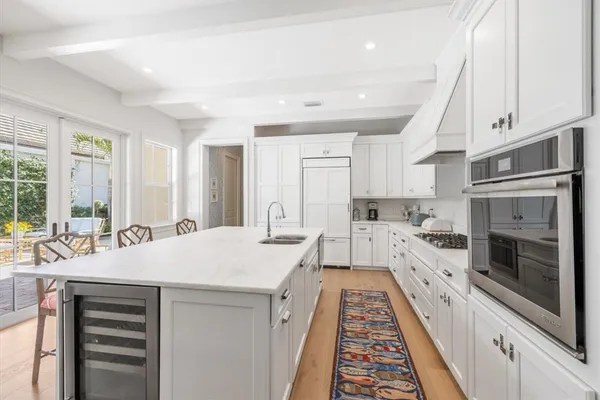 a large white kitchen with sink stove and refrigerator