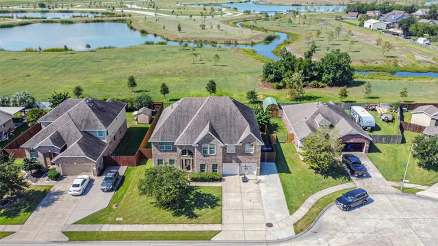 an aerial view of a house with a yard and lake view