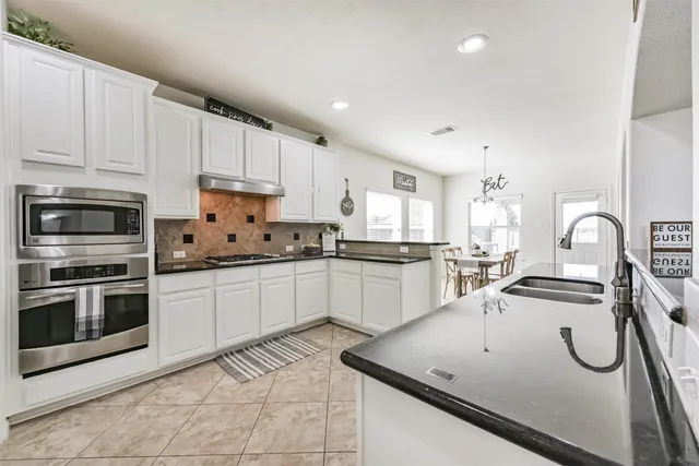 a kitchen with a sink a stove and cabinets