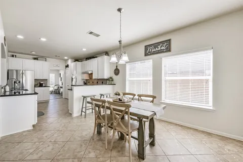 a large kitchen with a table and chairs