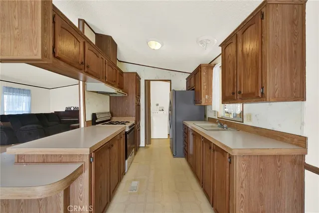 a kitchen with stainless steel appliances a sink and a refrigerator