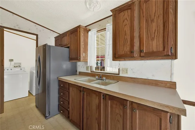 a kitchen with stainless steel appliances granite countertop a refrigerator a sink and dishwasher