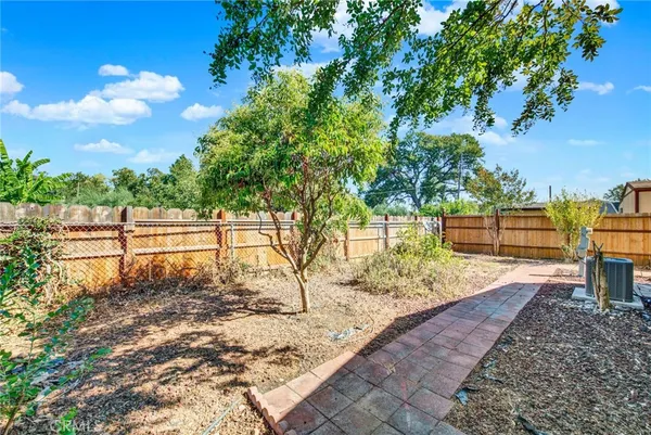 a view of a backyard with large trees and wooden fence