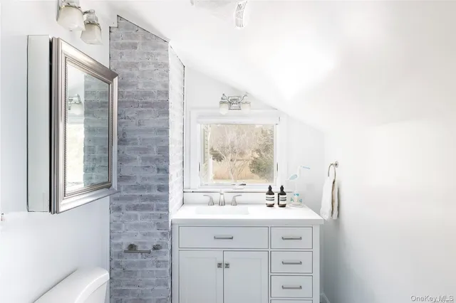 a bathroom with a sink mirror and a window