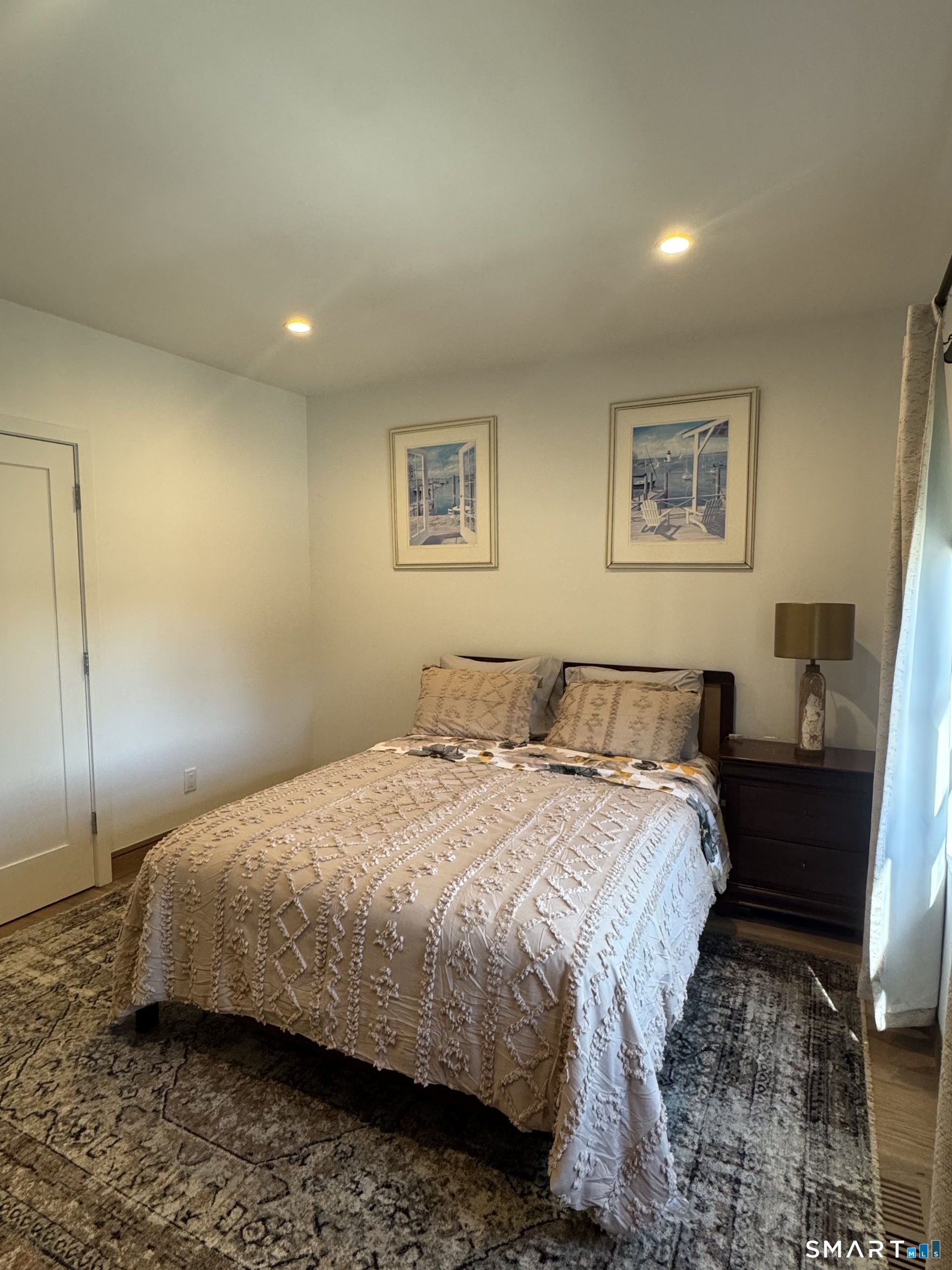 930 Cove Road, Unit 2 Stamford, CT 06902 - Photo 8 of 14 a bedroom with a bed and wooden floor