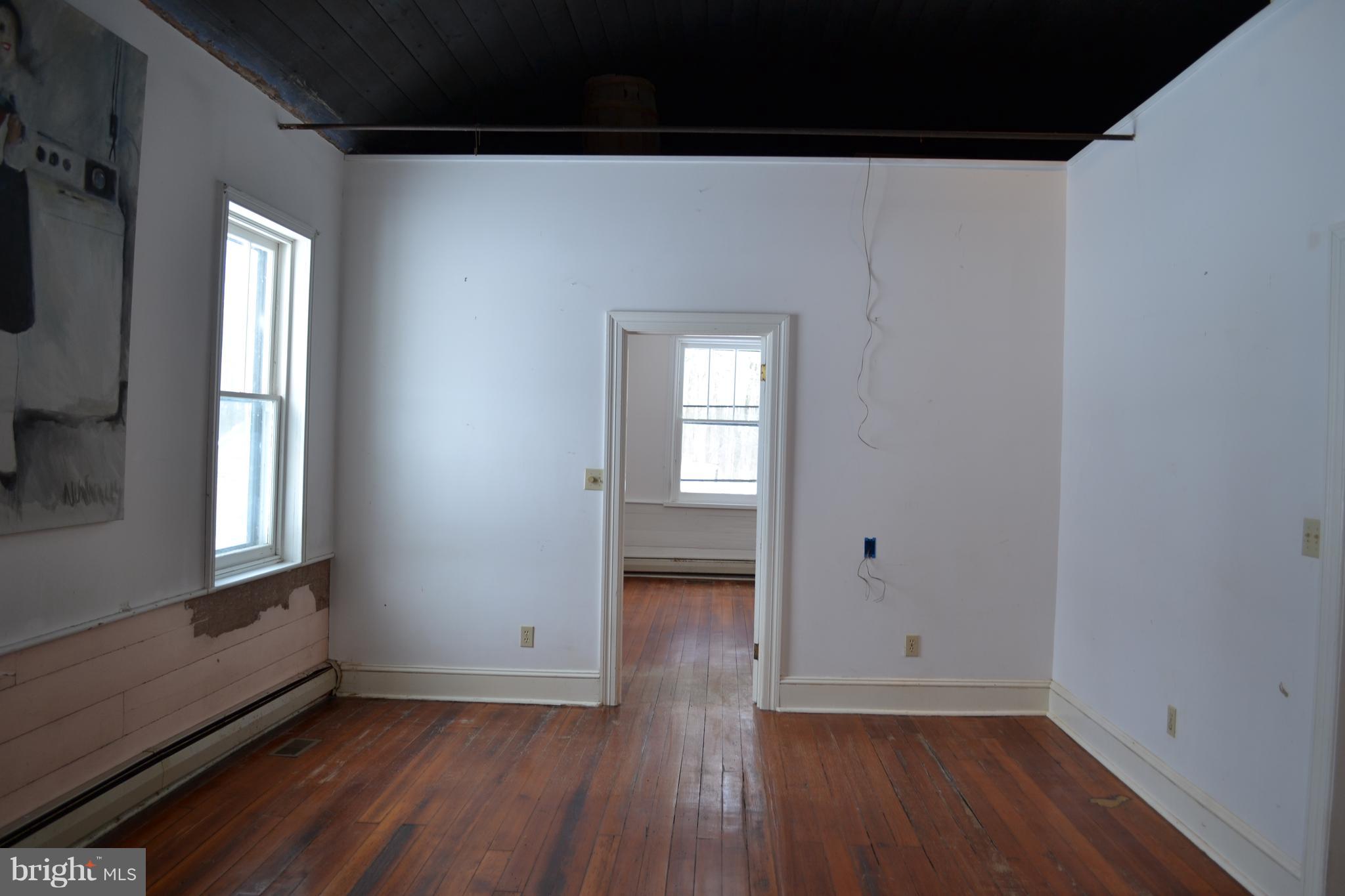 10539 Highland School Road Frederick, MD 21702 - Photo 8 of 18 a view of an empty room with wooden floor and a window