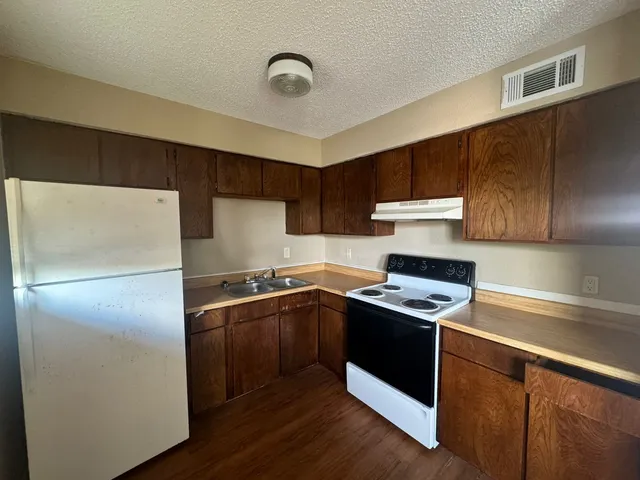 a kitchen with a refrigerator sink and cabinets