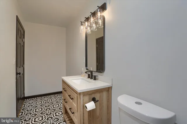 a bathroom with a sink a toilet and mirror