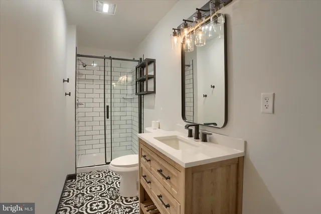 a bathroom with a sink a toilet and shower