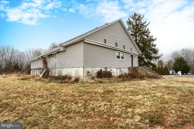 a front view of house with yard and trees in the background
