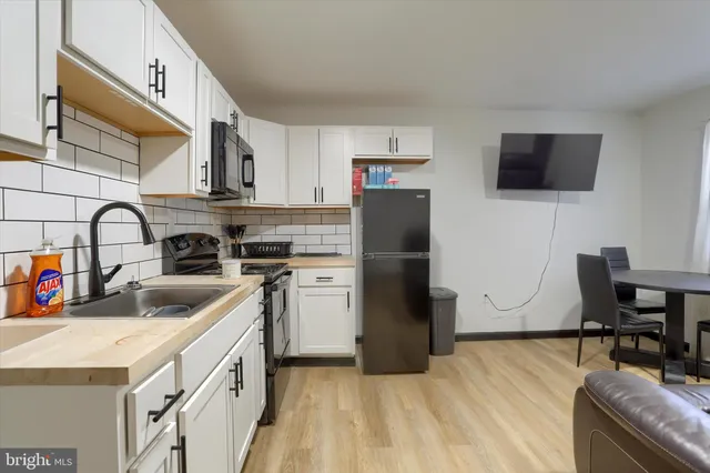 a kitchen with a sink a refrigerator and a stove top oven