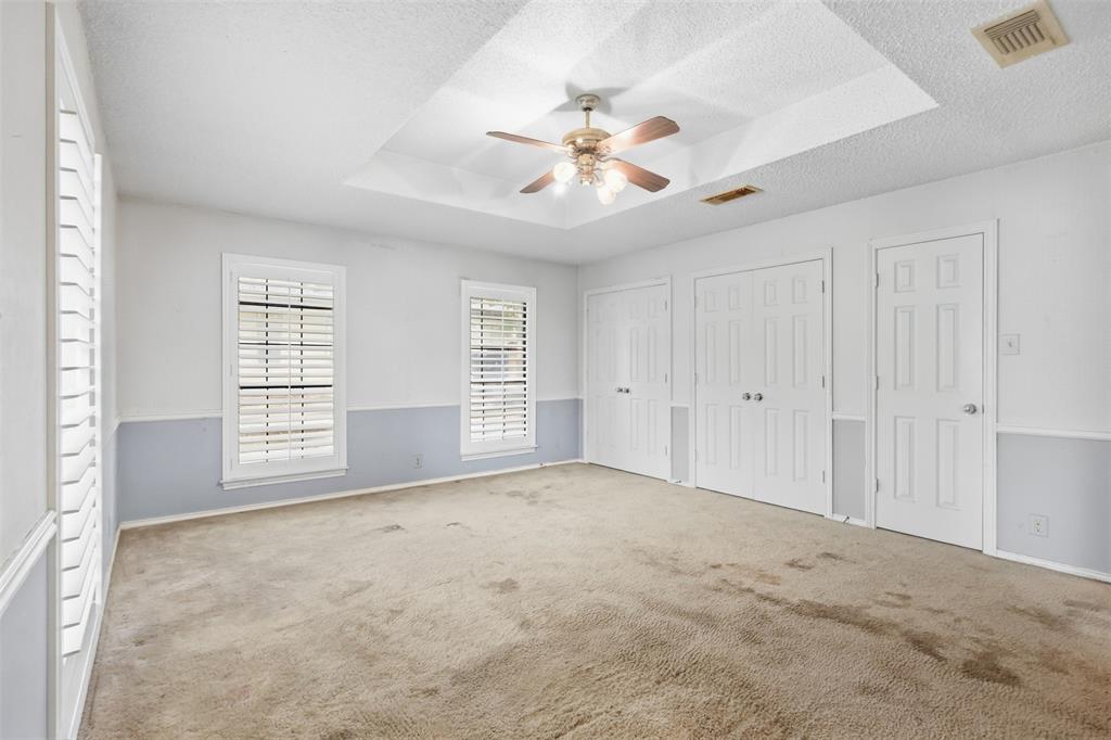 37 Timbergreen Circle Denton, TX 76205 - Photo 9 of 31 Tray ceiling with a ceiling fan light fixture, two-tone wall paint, multiple paneled doors, and plantation shutters
