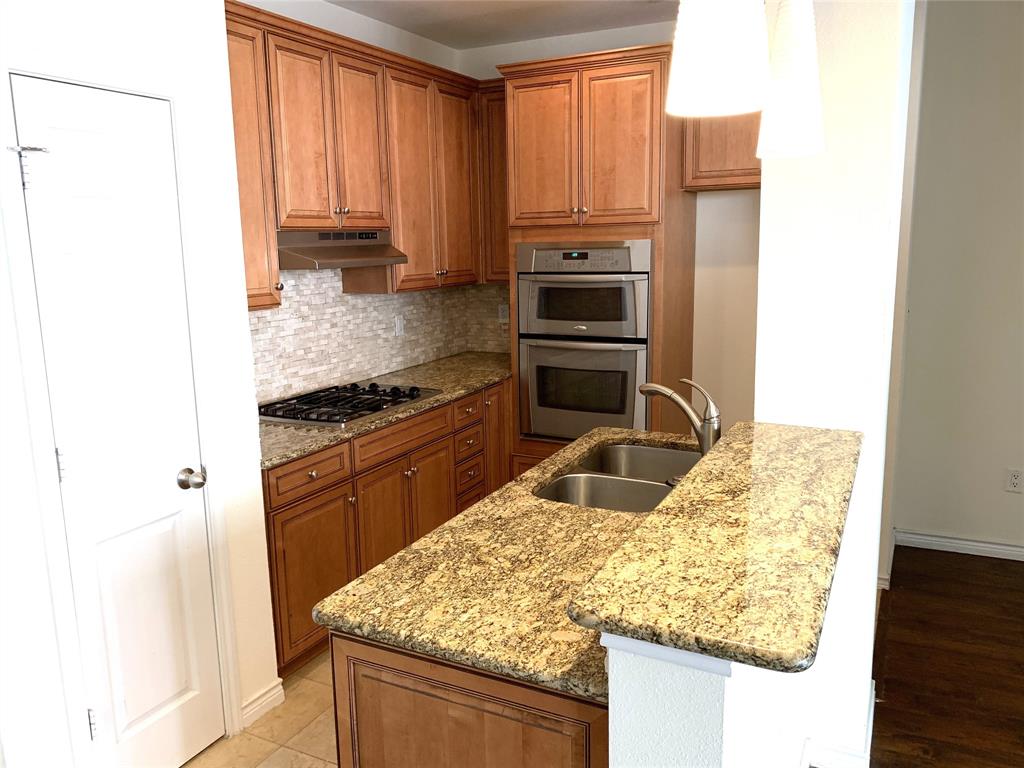 2106 Azure Pointe Richardson, TX 75080 - Photo 10 of 20 a kitchen with granite countertop a sink stove and refrigerator