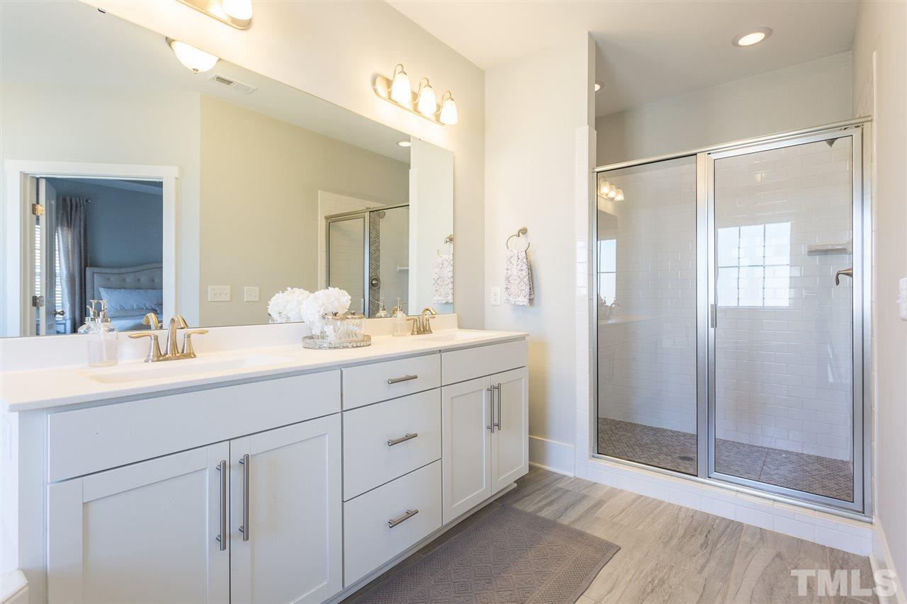 5410 Beckom Street Raleigh, NC 27616 - Photo 12 of 30 Luxurious and large master bathroom with dual vanities, tile flooring, custom walk in shower and spacious separate tub. Your oasis awaits!