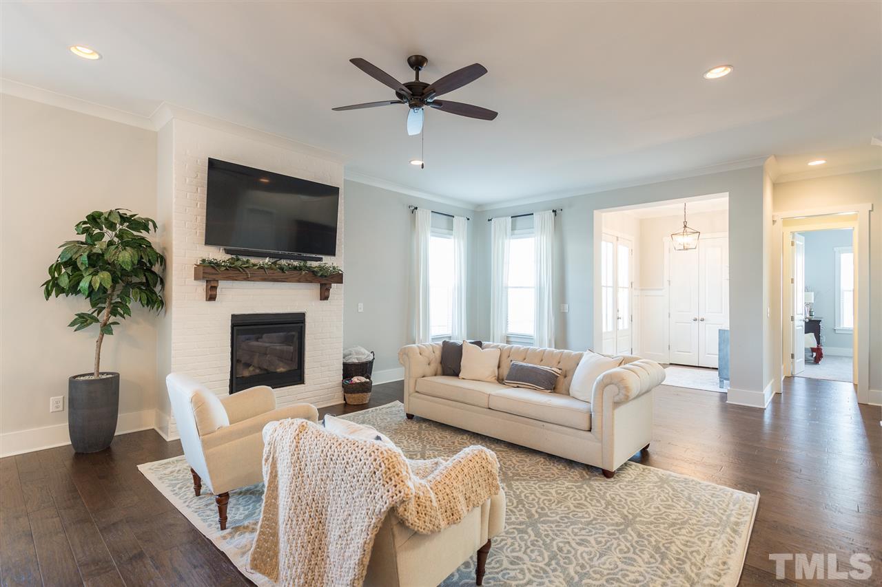 5410 Beckom Street Raleigh, NC 27616 - Photo 5 of 30 Spacious and cozy family room- Snuggle up to the custom gas fireplace with custom oak mantle. Beautiful, glistening hardwood floors too! Custom crown molding!