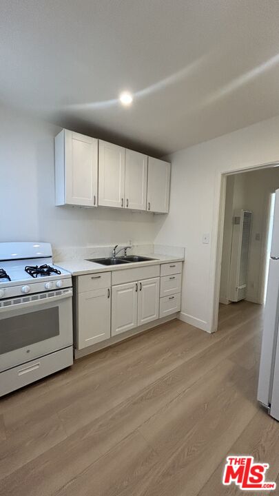 a kitchen with granite countertop white cabinets and white appliances