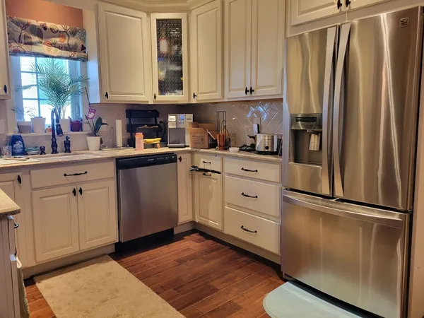 a kitchen with stainless steel appliances granite countertop a refrigerator sink and cabinets