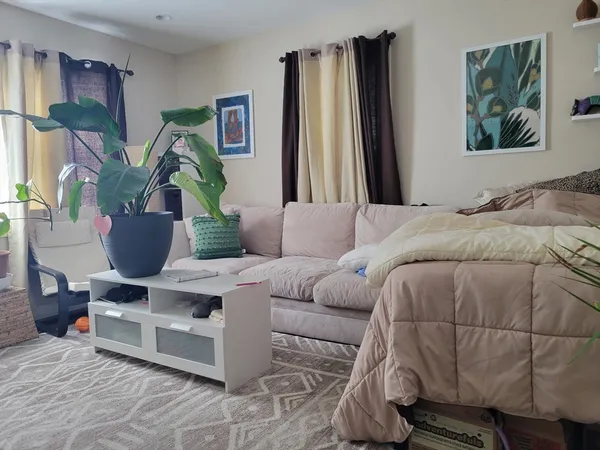 a living room with furniture and a painting on the wall