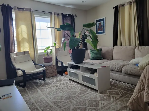 a living room with furniture a window and a flat screen tv