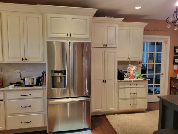 a kitchen with stainless steel appliances white cabinets and a refrigerator