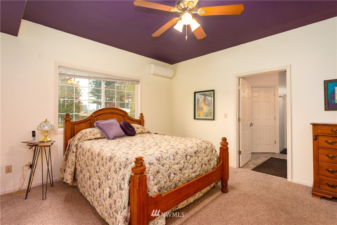 879 East Wiser Lake Road Lynden, WA 98264 - Photo 16 of 36 a bedroom with a bed and a chandelier
