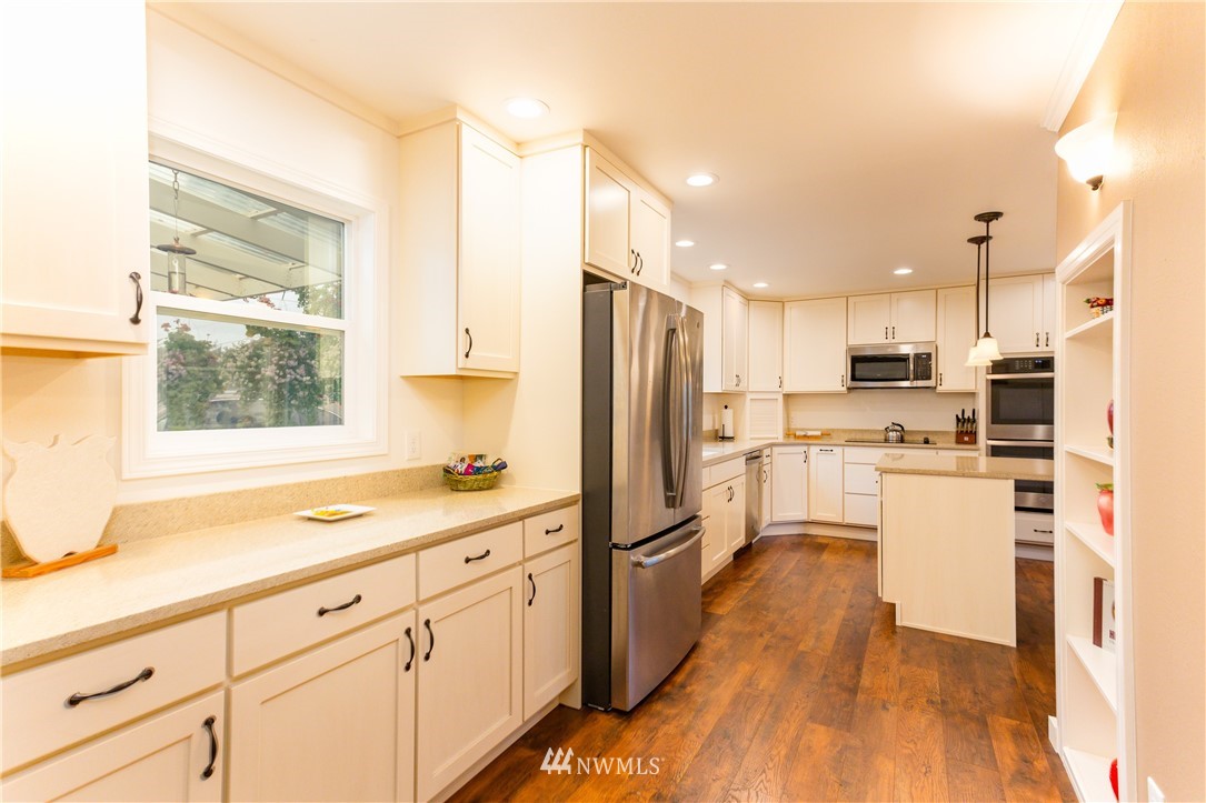 879 East Wiser Lake Road Lynden, WA 98264 - Photo 4 of 36 a kitchen with white cabinets and stainless steel appliances