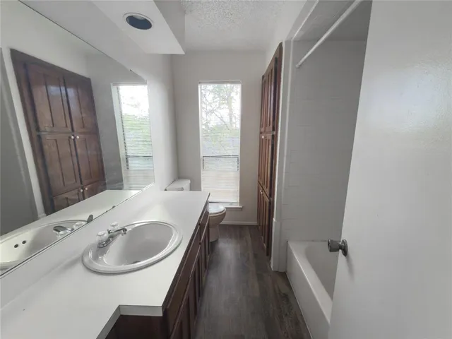a bathroom with a sink a bathtub and a window