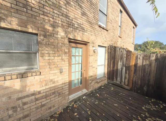 a view of a balcony with wooden floor and fence