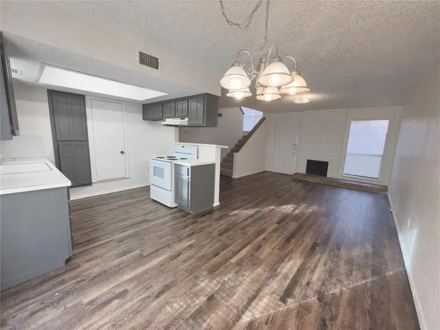 a view of a room with wooden floor and chandelier