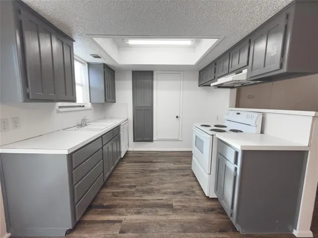 a kitchen with a sink stove top oven and cabinets