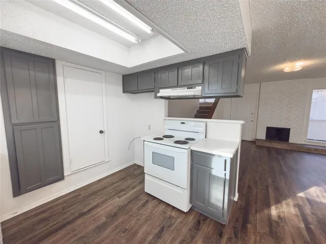 a kitchen with a stove and a wooden floors