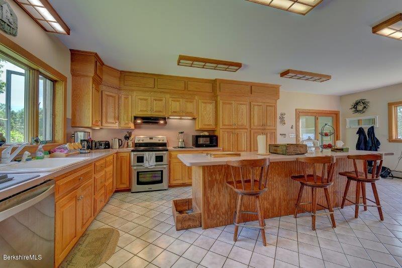 188 Huntington Road Worthington, MA 01098 - Photo 15 of 37 a large kitchen with kitchen island a stove a sink a table and chairs
