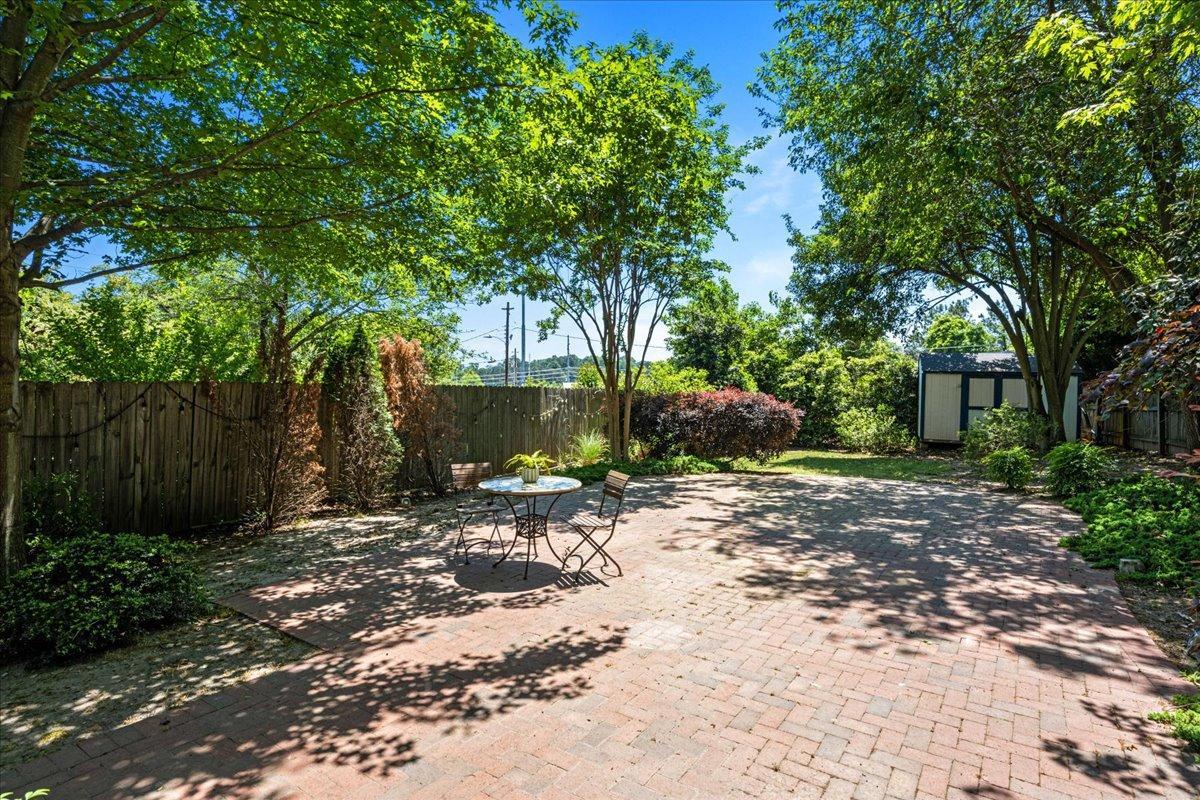 406 Pershing Road Raleigh, NC 27608 - Photo 6 of 29 a view of a backyard with large tree and wooden fence