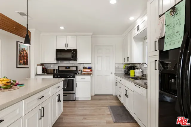 a kitchen with stainless steel appliances a stove refrigerator sink and microwave