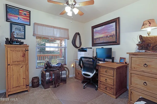 a view of a workspace with furniture and a window