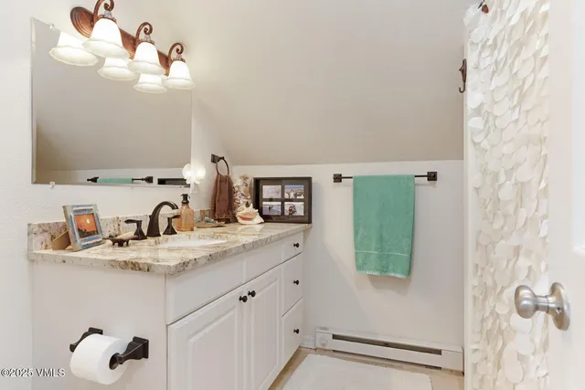 a bathroom with a granite countertop sink a mirror and vanity