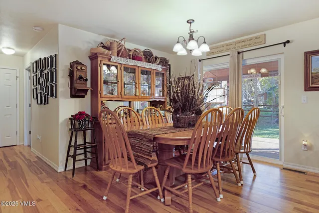 a view of a dining room with furniture wooden floor and chandelier